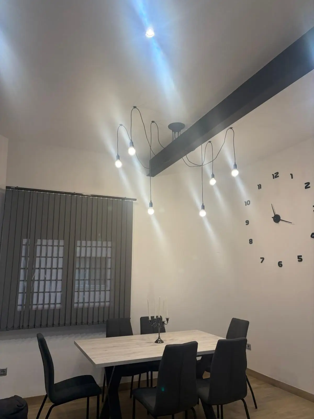 Reforma integral de comedor con lámpara de cables colgantes sobre mesa de madera en Tarragona