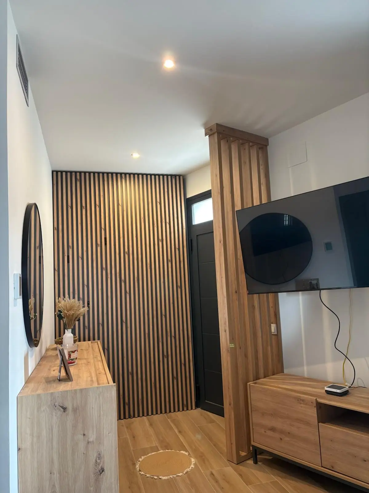 Reforma integral con panelado de listones de madera y separador de ambientes en Tarragona